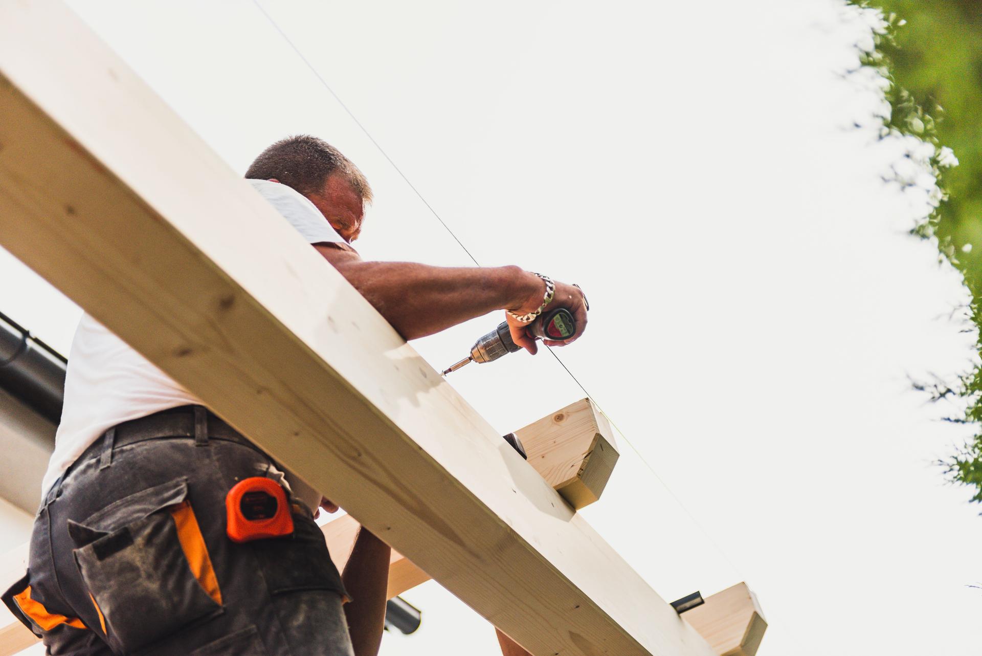 Construction worker on the wooden frame of a roof